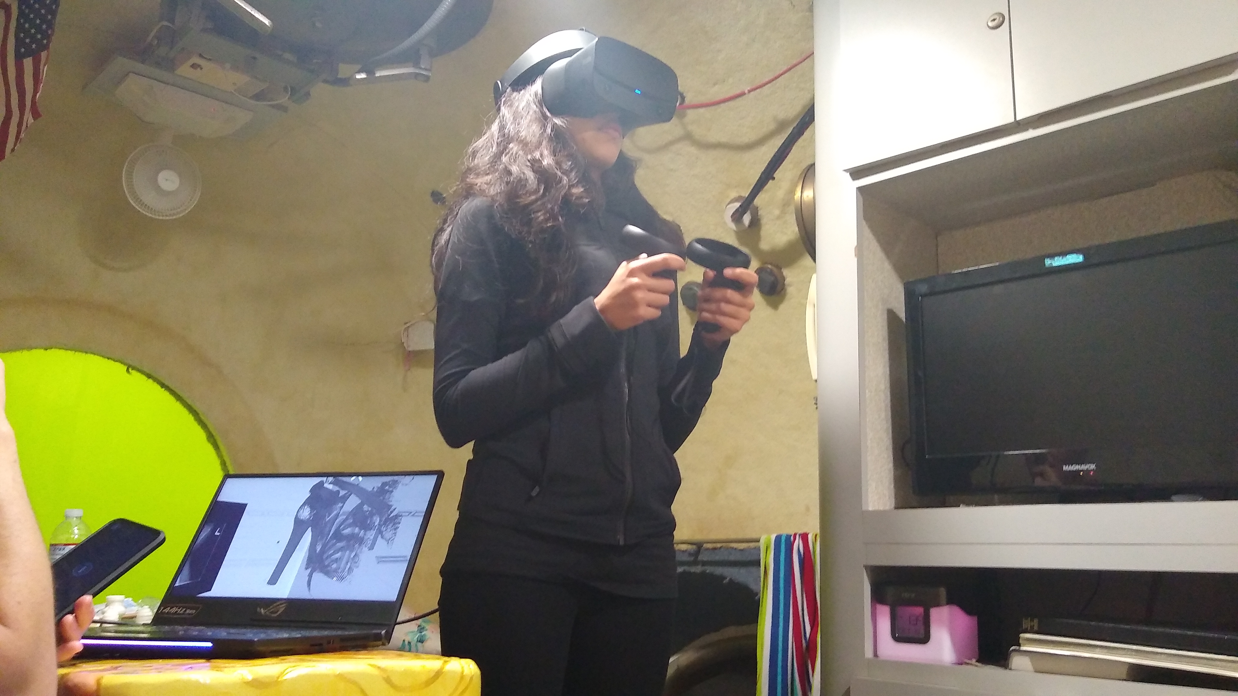 Female wearing a virtual reality headset and holding controller.